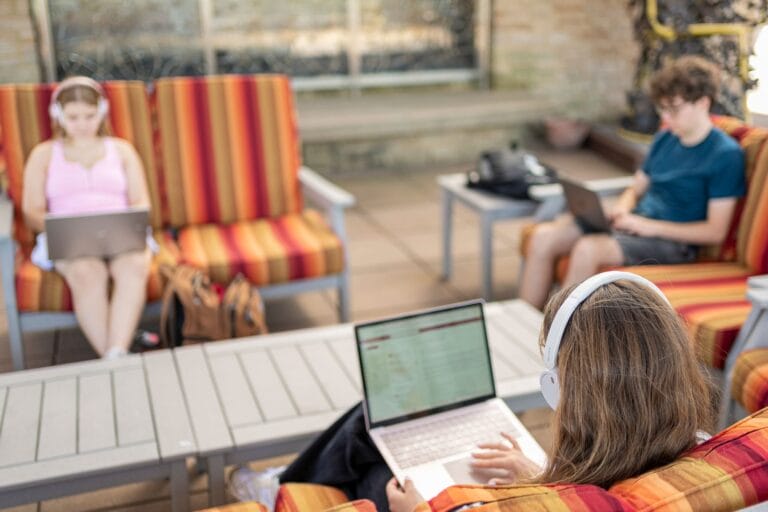 Summer Term students working on laptops outside