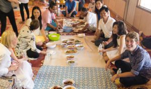 Students participating in a group meal hosted by the Language Institutes
