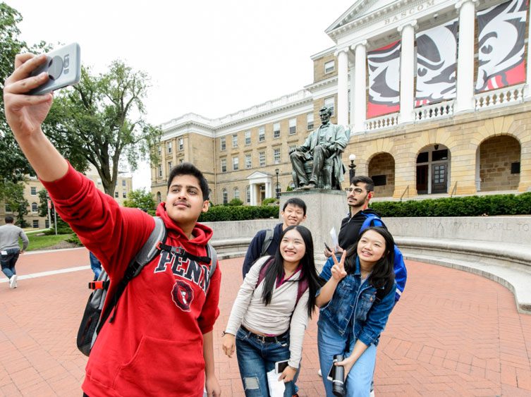 ISSI students taking a selfie in front of the Abraham Lincoln state on Bascom Hill