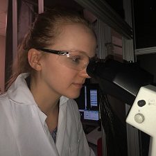 Student Rebecca Schmitz looking in a microscope