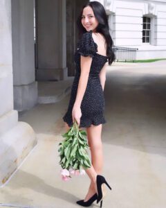 Melanie Lafountain posing in dress, holding flowers