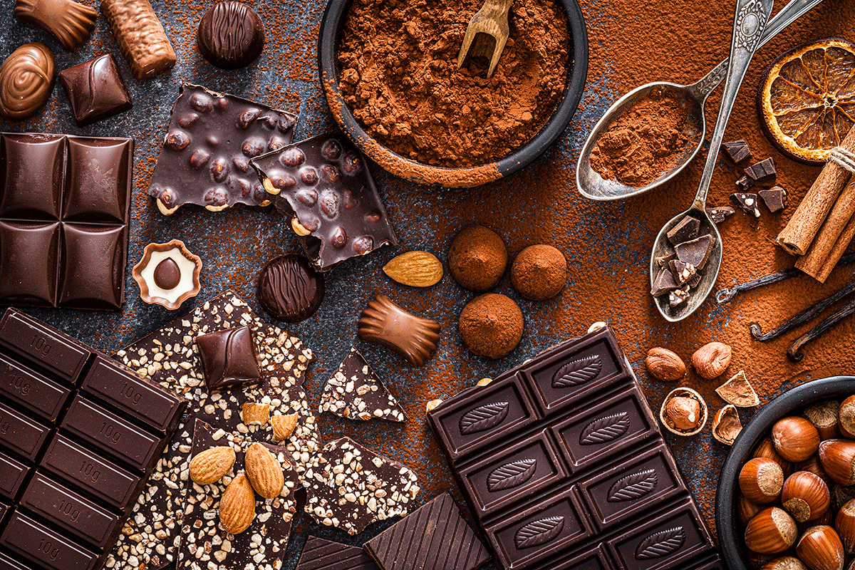 dIfferent kinds of chocolate and cocoa sitting on a table, decoratively placed