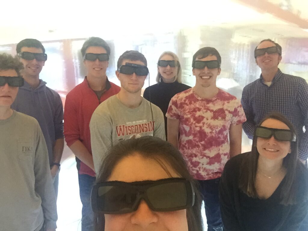 Group of students wearing virtual reality headsets and smiling
