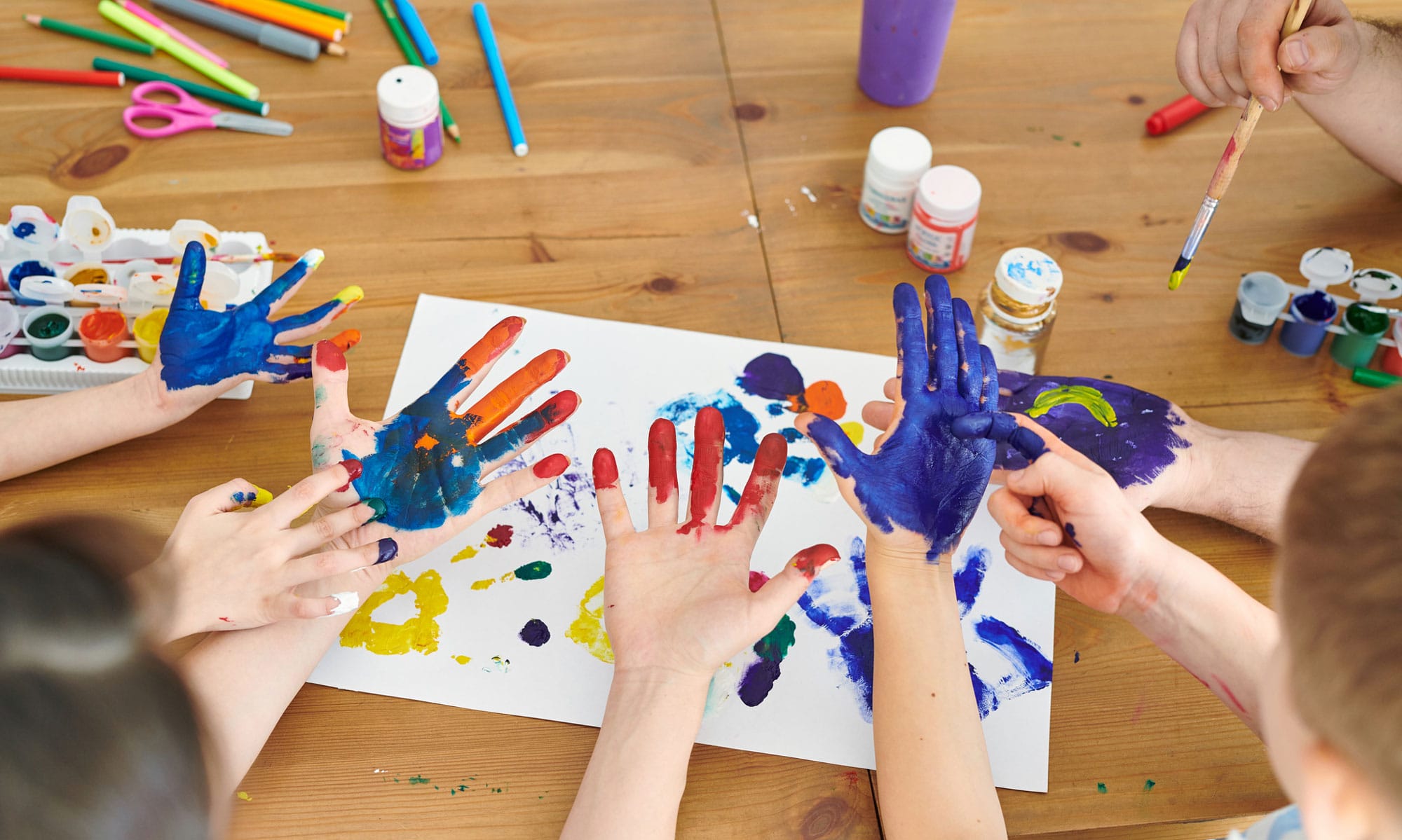 Two pairs of hands coated in paint.