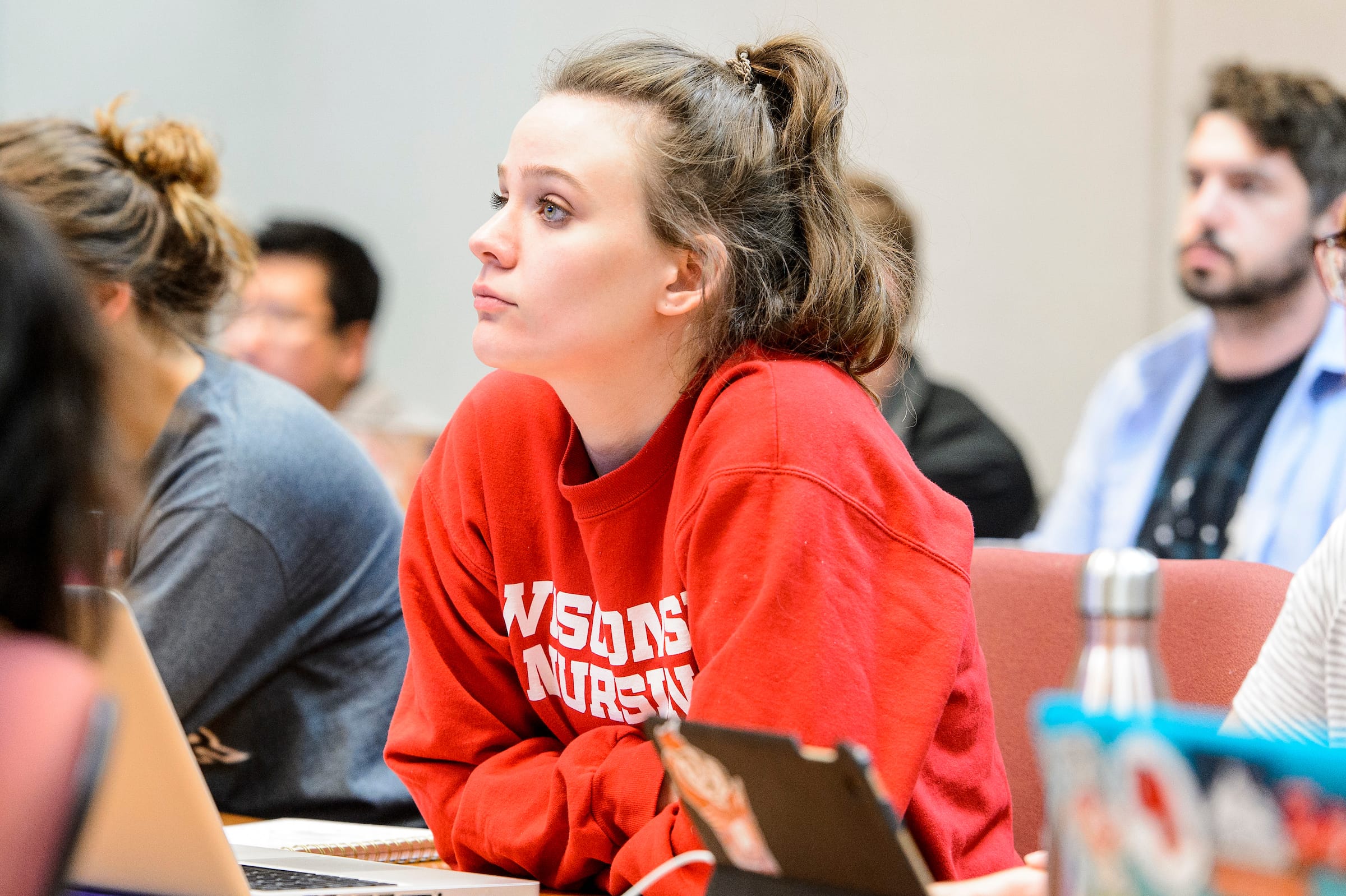 A student wearing a UW-Madison sweater. attending lecture.