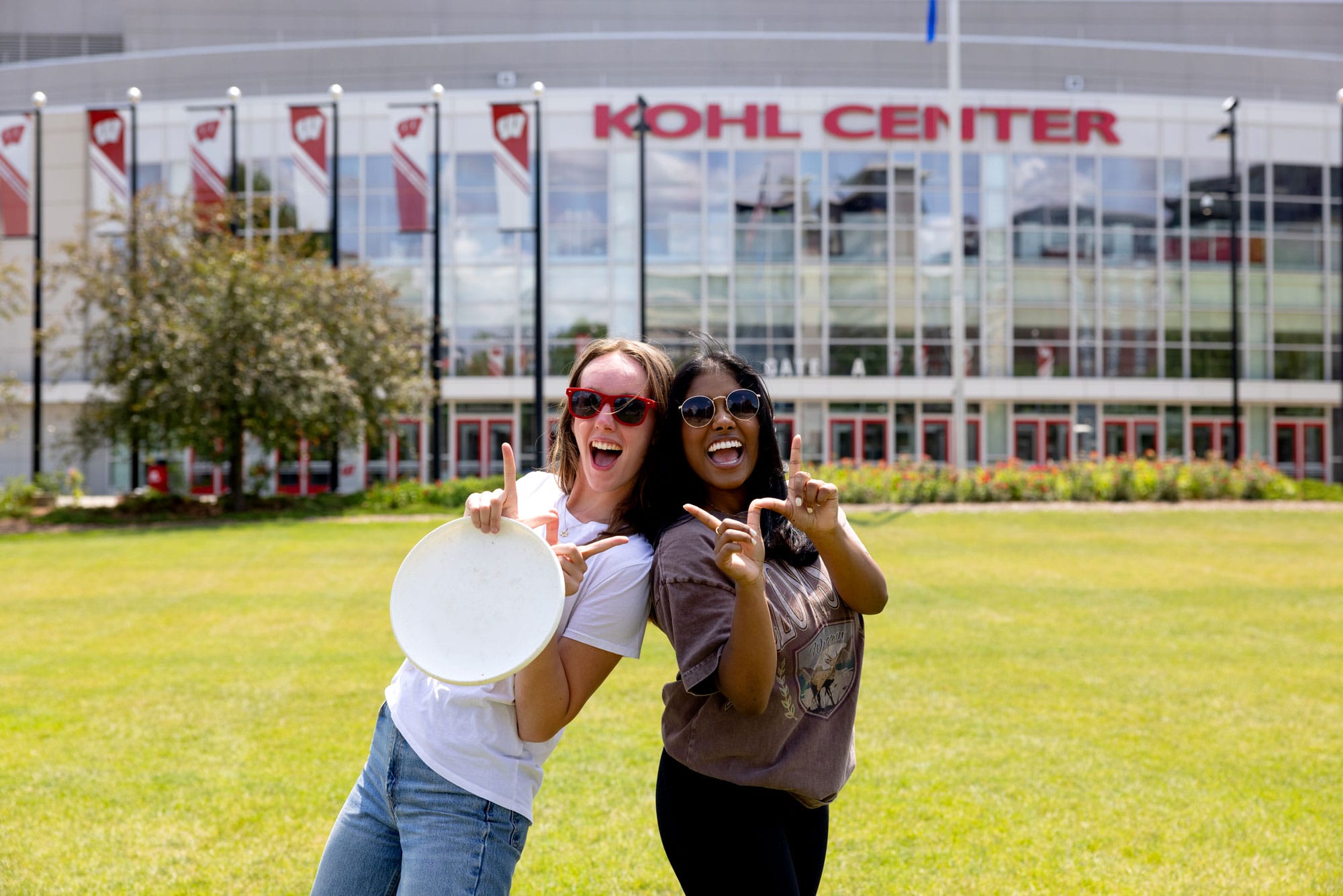 Two UW-Madison students posing for a selfie outside the Kohl Center.