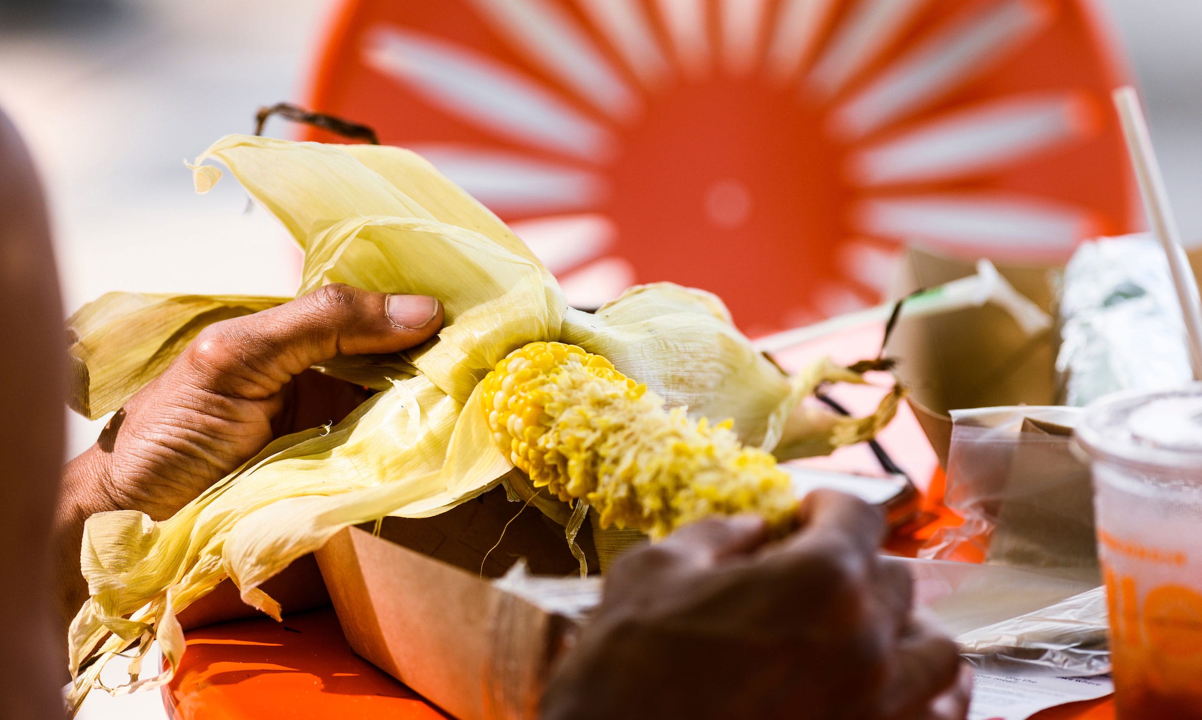 Closeup of someone eating corn on the cob at the Memorial Union Terrace