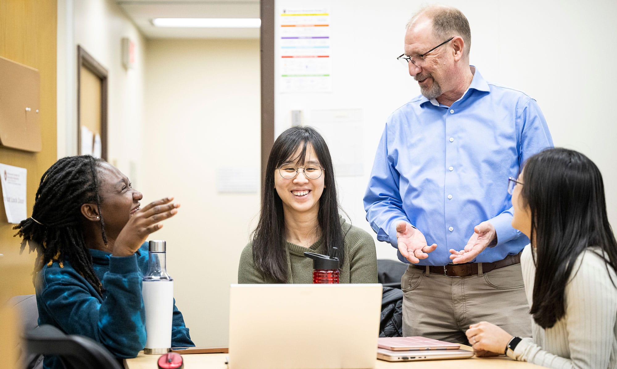 Students speaking with professor in an Educational Psychology class