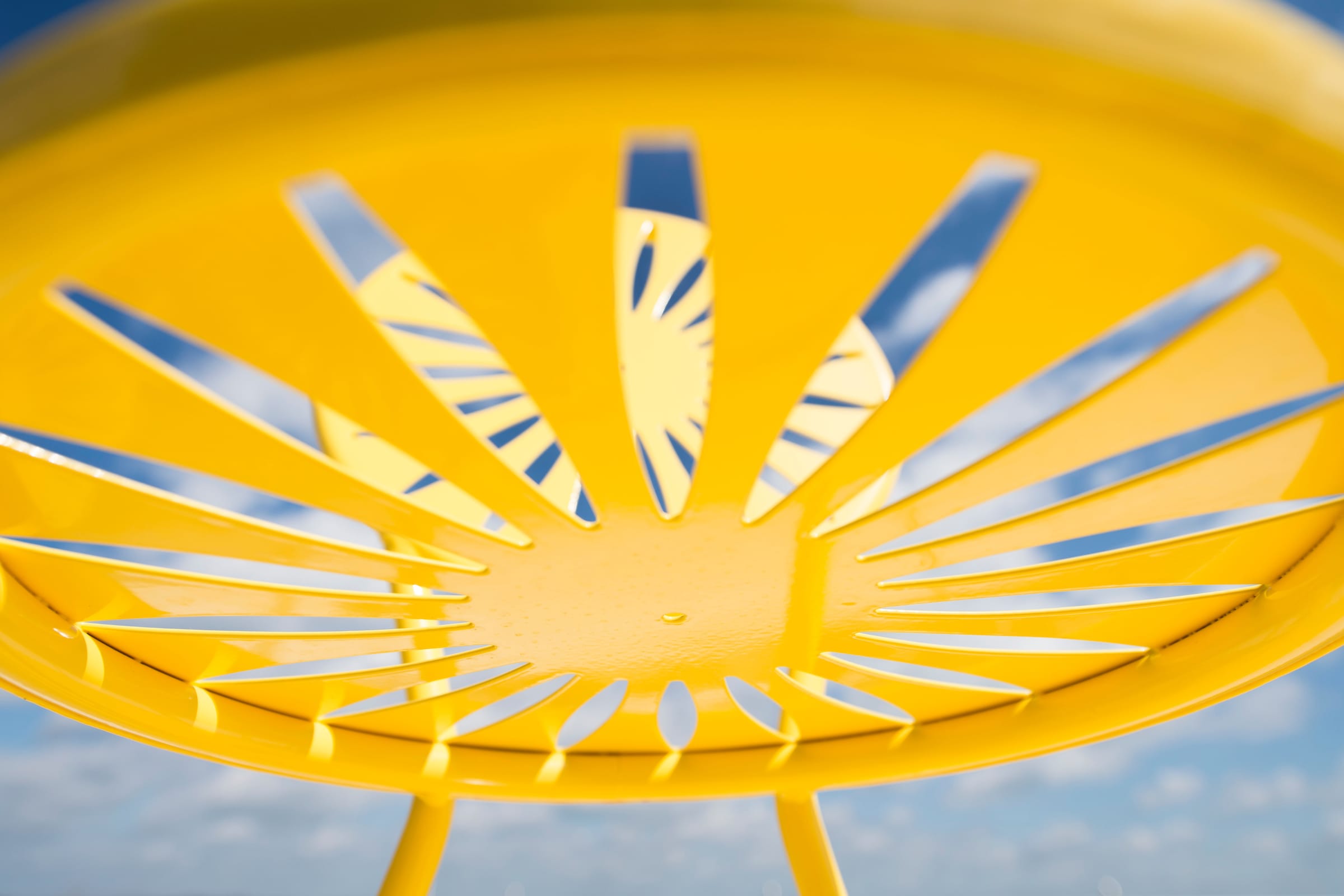 Closeup shot of a yellow Memorial Union Terrace chair against a blue sky