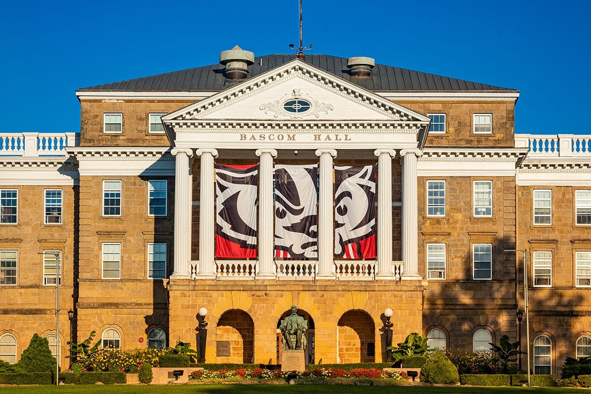 UW–Madison's Bascom Hall shown with Bucky Badger banner displayed behind columns.