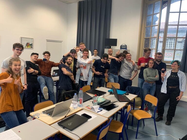 Students standing in a classroom for a group photo, smiling