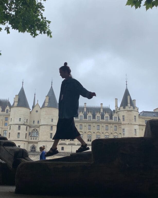 Silhouette of student walking on a wall with castle-like building in background