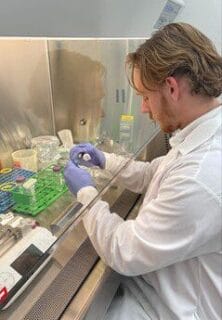 Nicholas Rienstra in a lab, wearing a white lab coat