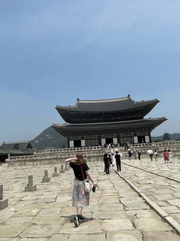 Students walking a stone pathway to a temple-like building in South Korea