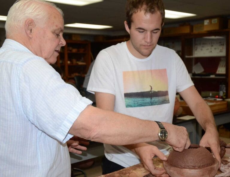 Professor Kenoyer working with a student on making pottery.