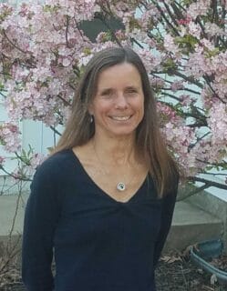 headshot of instructor Monica Theis in front of a blooming tree