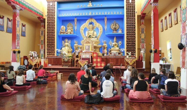 students sitting on meditation cushions at the Deer Creek Buddhist Center, in a colorful room